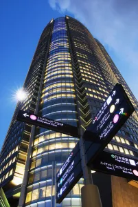 Japan, Roppongi Hills at dusk; Tokyo, Directional sign and Mori Tower Japan, Roppongi Hills at dusk; Tokyo, Directional sign and Mori Tower