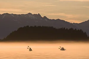 Kayakers Paddling Through The Misty Waters Of Favorite Passage, Near Sentinel Island. Summer In Southeast Alaska Kayakers Paddling Through The Misty Waters Of Favorite Passage, Near Sentinel Island. Summer In Southeast Alaska
