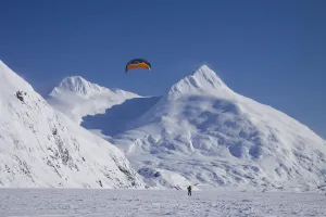 A Kite-Skier Skis On Portage Lake With Chugach Mountains In The Background, Southcentral A Kite-Skier Skis On Portage Lake With Chugach Mountains In The Background, Southcentral