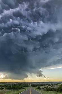 Mammatus lit up by lightning as it crosses a highway Mammatus lit up by lightning as it crosses a highway