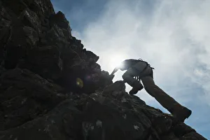 Man Scrambling Up Ridge In The Black Cuillin; Isle Of Skye, Scotland Man Scrambling Up Ridge In The Black Cuillin; Isle Of Skye, Scotland