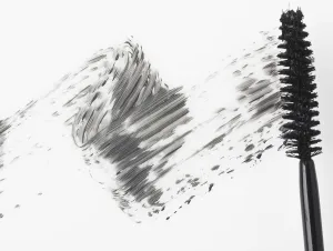 Mascara brush leaving traces of mascara on a white background Mascara brush leaving traces of mascara on a white background