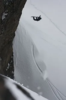 Professional Snowboarder Making An Extreme Jump Of A Vertical Wall Near Ushuaia, Patagonia Professional Snowboarder Making An Extreme Jump Of A Vertical Wall Near Ushuaia, Patagonia