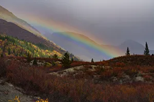 Rainbow across the vast mountainous landscape off of the Nahanni Range Road in the Yukon; Yukon, Canada Rainbow across the vast mountainous landscape off of the Nahanni Range Road in the Yukon; Yukon, Canada
