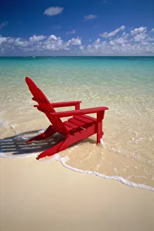 Red Beach Chair Along Shoreline, Turquoise Ocean, Calm Red Beach Chair Along Shoreline, Turquoise Ocean, Calm