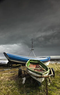 Images Dated 8th April 2012: Rowboats sitting on trailers on the shore under storm clouds; Boulmer northumberland england