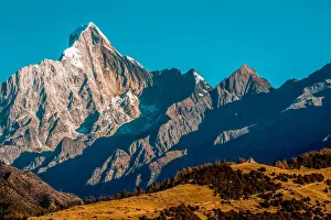 Rugged mountainous terrain of Mount Siguniang under a bright blue sky, Siguniang National Park; Ngawa Prefecture Rugged mountainous terrain of Mount Siguniang under a bright blue sky, Siguniang National Park; Ngawa Prefecture