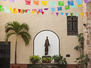 A sculpture of san francisco de assisi is sheltered by the church of our lady of guadalupe; Puerto vallarta mexico A sculpture of san francisco de assisi is sheltered by the church of our lady of guadalupe; Puerto vallarta mexico