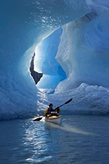 Sea Kayaker On Mendenhall Lake With Big Blue Iceberg In The Background, Southeast Alaska, Summer Sea Kayaker On Mendenhall Lake With Big Blue Iceberg In The Background, Southeast Alaska, Summer