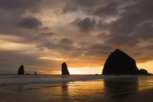 Silhouette Of Rock Formations And Haystack Rock At Sunset; Cannon Beach, Oregon, United States of America Silhouette Of Rock Formations And Haystack Rock At Sunset; Cannon Beach, Oregon, United States of America