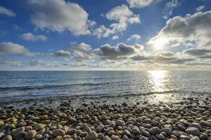 Sky with Clouds and Sun over pebble Beach, Summer, Sealands Odde, Odsherred, Baltic Sea, Zealand, Denmark Sky with Clouds and Sun over pebble Beach, Summer, Sealands Odde, Odsherred, Baltic Sea, Zealand, Denmark