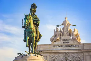 Statue of King Jose I in Commerce Square (Praca do Comercio) with Arco da Rua Augusta in the background against a blue Statue of King Jose I in Commerce Square (Praca do Comercio) with Arco da Rua Augusta in the background against a blue