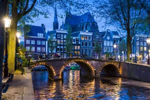 Stone bridge lit up at dusk along the Leidsegracht Canal in Amsterdam, Holland Stone bridge lit up at dusk along the Leidsegracht Canal in Amsterdam, Holland
