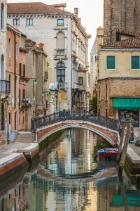 Stone footbridge with iron railing crossing a canal in Venice, Italy Stone footbridge with iron railing crossing a canal in Venice, Italy