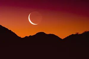 Sunrise over a mountain range in joshua tree national park with the moon in the sky Sunrise over a mountain range in joshua tree national park with the moon in the sky