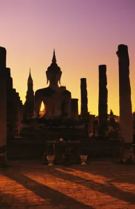 Thailand, Sukhothai, Wat Mahathat, Buddha And Pillars Backlit At Sunset Thailand, Sukhothai, Wat Mahathat, Buddha And Pillars Backlit At Sunset