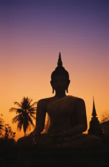 Thailand, Sukhothai, Wat Mahathat At Sunset, Silhouetted Buddha Statue, Purple And Orange Sky Thailand, Sukhothai, Wat Mahathat At Sunset, Silhouetted Buddha Statue, Purple And Orange Sky