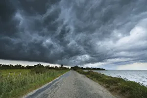 Thunder Storm over Country Road, Etang de Vaccares, Camargue, Bouches-du-Rhone, Provence-Alpes-Cote d'Azur, France Thunder Storm over Country Road, Etang de Vaccares, Camargue, Bouches-du-Rhone, Provence-Alpes-Cote d'Azur, France