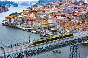 Train on the Dom Luis I Bridge and harbor with the Arrabida Bridge in the distance in Porto, Norte, Portugal Train on the Dom Luis I Bridge and harbor with the Arrabida Bridge in the distance in Porto, Norte, Portugal
