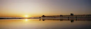 USA, Reflections On Beach; California, Oceanside Pier And Surfers Silhouetted Against USA, Reflections On Beach; California, Oceanside Pier And Surfers Silhouetted Against