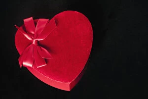 Valentines heart-shaped candy box against black background