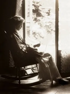 Woman in a rocking chair in front of the window, circa 1900 Woman in a rocking chair in front of the window, circa 1900