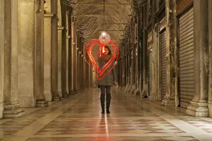 Light Painting Gallery: A Woman Walking In A Corridor Making A Red Heart Shape In The Air With Light Trails; Venice
