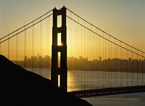 Yellow Sunrise Behind The Golden Gate Bridge With Skyline Behind