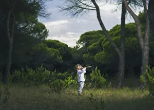 A Young Boy Looks Through A Telescope Standing In The Grass; Tarifa, Cadiz, Andalusia, Spain A Young Boy Looks Through A Telescope Standing In The Grass; Tarifa, Cadiz, Andalusia, Spain