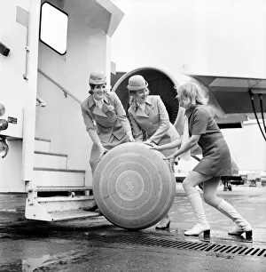 3 air hostesses rolling along a wheel of some sort A 2 *** Local Caption *** 3 air hostesses rolling along a wheel of some sort A 2 *** Local Caption ***