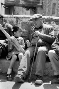 6 year old Nathalie Rustan with her French loaves of bread talks to pensioner Michel 6 year old Nathalie Rustan with her French loaves of bread talks to pensioner Michel