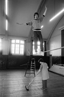 Images Dated 8th April 1981: Actor Michael Crawford works out on the high wire with a charlady sweeping the floor