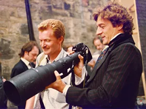 Actor Nigel Havers inspecting photographer Nigel Roddis's camera and lens Actor Nigel Havers inspecting photographer Nigel Roddis's camera and lens