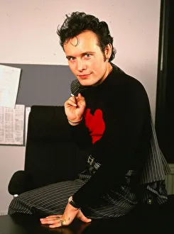 Adam Ant pop singer January 1990 Sittingon desk black jumper red heart striped Adam Ant pop singer January 1990 Sittingon desk black jumper red heart striped