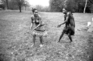 African Dancing: Ghanan Dancers. A bare-topped dancer gets chased by one of the boy African Dancing: Ghanan Dancers. A bare-topped dancer gets chased by one of the boy