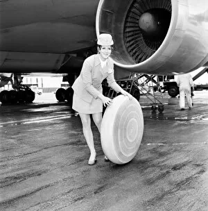 Images Dated 15th April 1970: Air hostess sitting by a plane rolling a wheel along. A 2 *** Local Caption