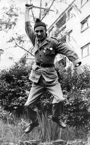 Alex McGibben jumping in the air brandishing a large knife. May 1978 P035519 Alex McGibben jumping in the air brandishing a large knife. May 1978 P035519