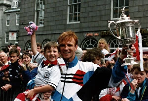 Images Dated 13th May 1990: Alex McLeish of Aberdeen Football Club in the street holding up his son in one hand