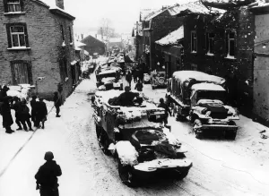 00154 Gallery: American troops pass through snow-covered street in Lierheux Belgium during WW2
