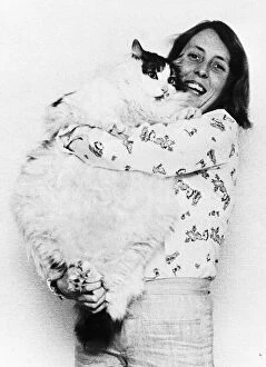 Images Dated 19th April 1977: Animals Cats Gill Dacey struggles to hold up her pet pussy cat Tiger