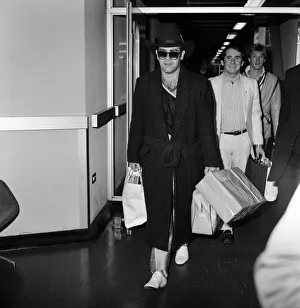 The arrival of Elton John at Heathrow Airport carrying Christmas presents from a buying The arrival of Elton John at Heathrow Airport carrying Christmas presents from a buying