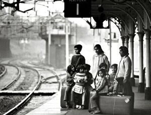 Asian immigrant family waiting at Bishops Stortford train station to travel to London