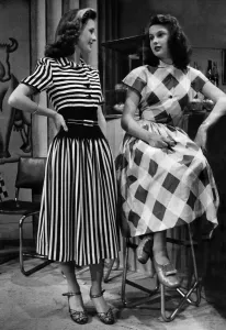 Audreywearing a brown and white striped dress. Rita in a big check pattern Audreywearing a brown and white striped dress. Rita in a big check pattern