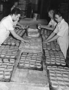 Bakers topping pies about to be put into the oven at a Edinburgh Bakery Bakers topping pies about to be put into the oven at a Edinburgh Bakery