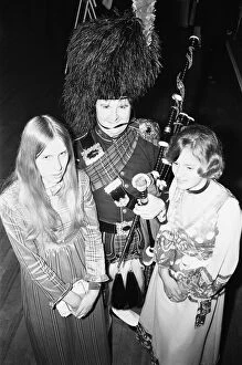Images Dated 31st December 1970: Two ball goers pose with the piper at the Birmingham and West Midlands Scottish Society