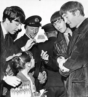 The Beatles Gallery: The Beatles chat with a young fan, and sign for her their autographs