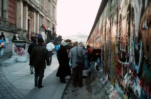 Berlin Wall in Germany with people chipping bits off the wall for souvenirs Berlin Wall in Germany with people chipping bits off the wall for souvenirs