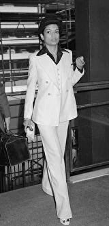 Bianca Jagger, wife of Mick Jagger, in white suit and bowler hat with silver topped cane