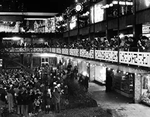 The blaze of lights from shops adds to the sparkle of Christmas lights as families gather The blaze of lights from shops adds to the sparkle of Christmas lights as families gather