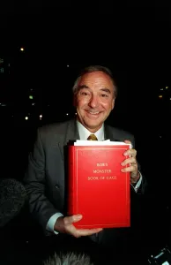 Bob Monkhouse Comedian and TV Presenter holding the book of gags that was stolen from his Bob Monkhouse Comedian and TV Presenter holding the book of gags that was stolen from his